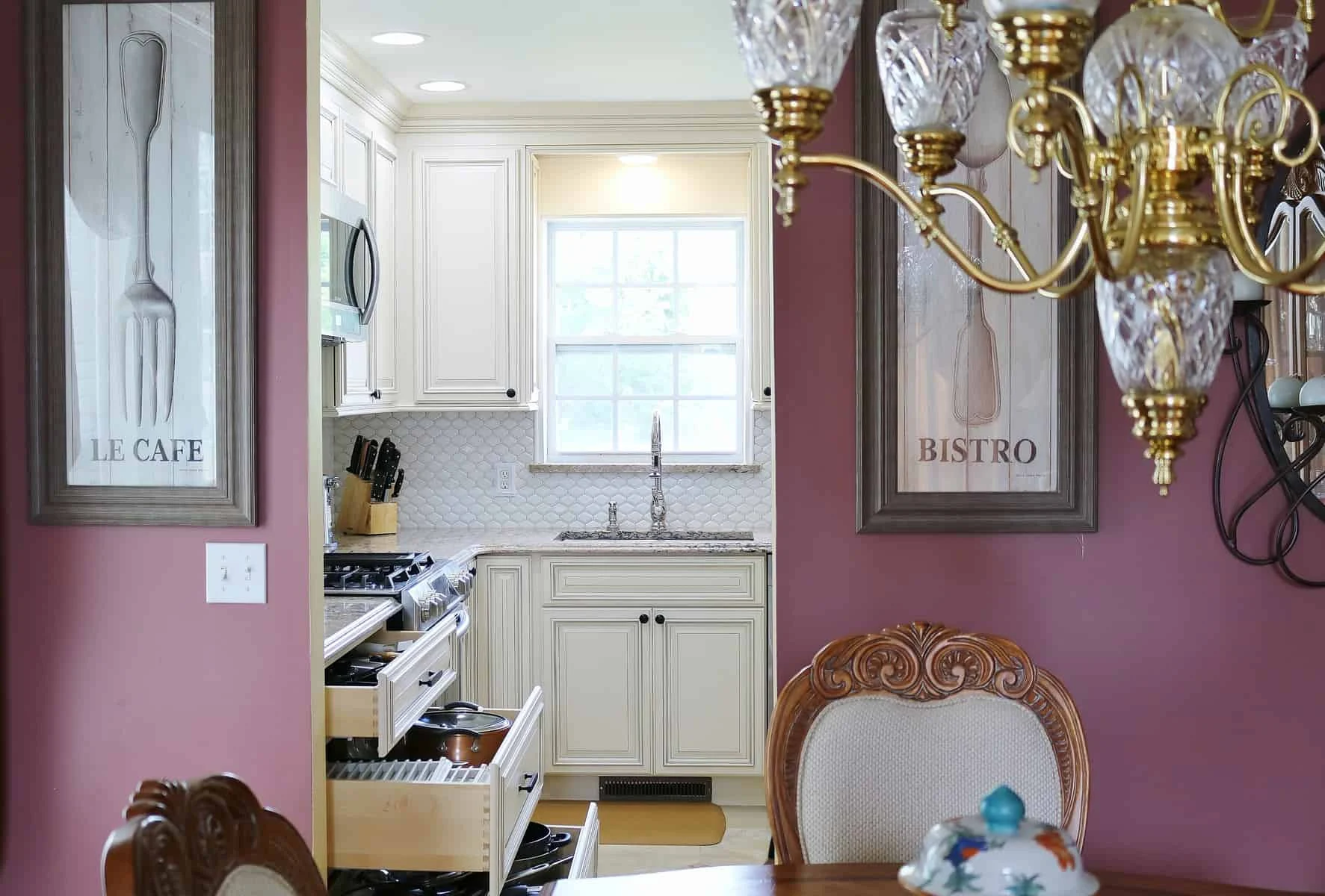 Kitchen with white cabinetry and pull-out storage viewed from dining room