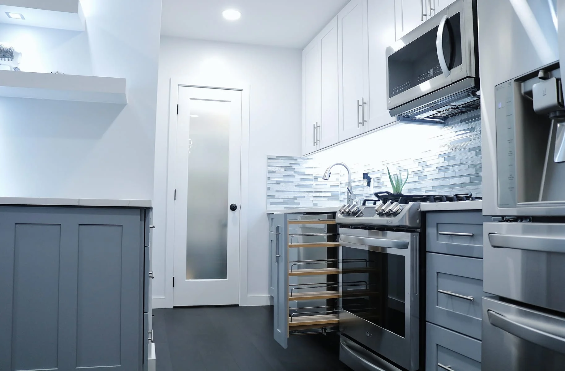 Kitchen with gray cabinets, quartz countertops, and pull-out storage