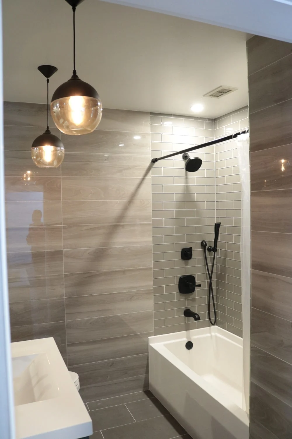 Condo Bathroom, full wall tiles, tub and vanity and large mirrors