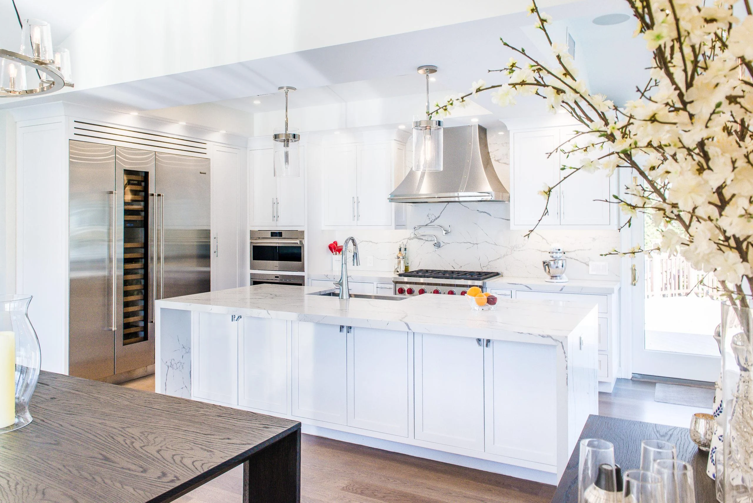 White kitchen with large island and stainless steel appliances in Westchester County home
