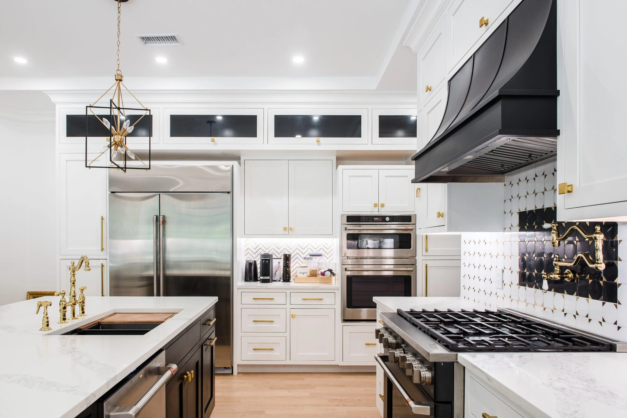 Custom kitchen design in Rye NY with professional range, black hood, and patterned backsplash