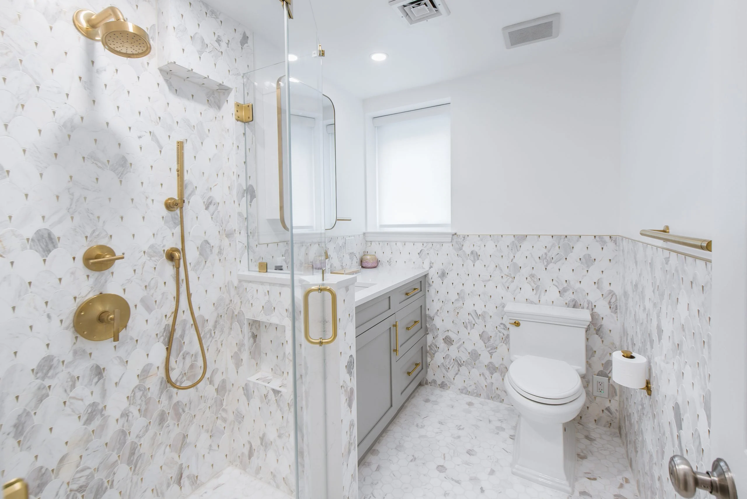 Basement bathroom renovation, marble tiles, custom glass and brass finishes