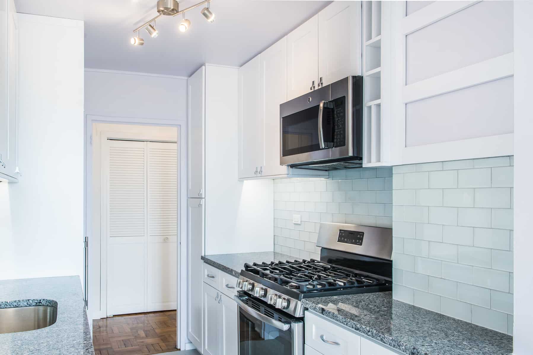 Microwave above range in white shaker cabinetry