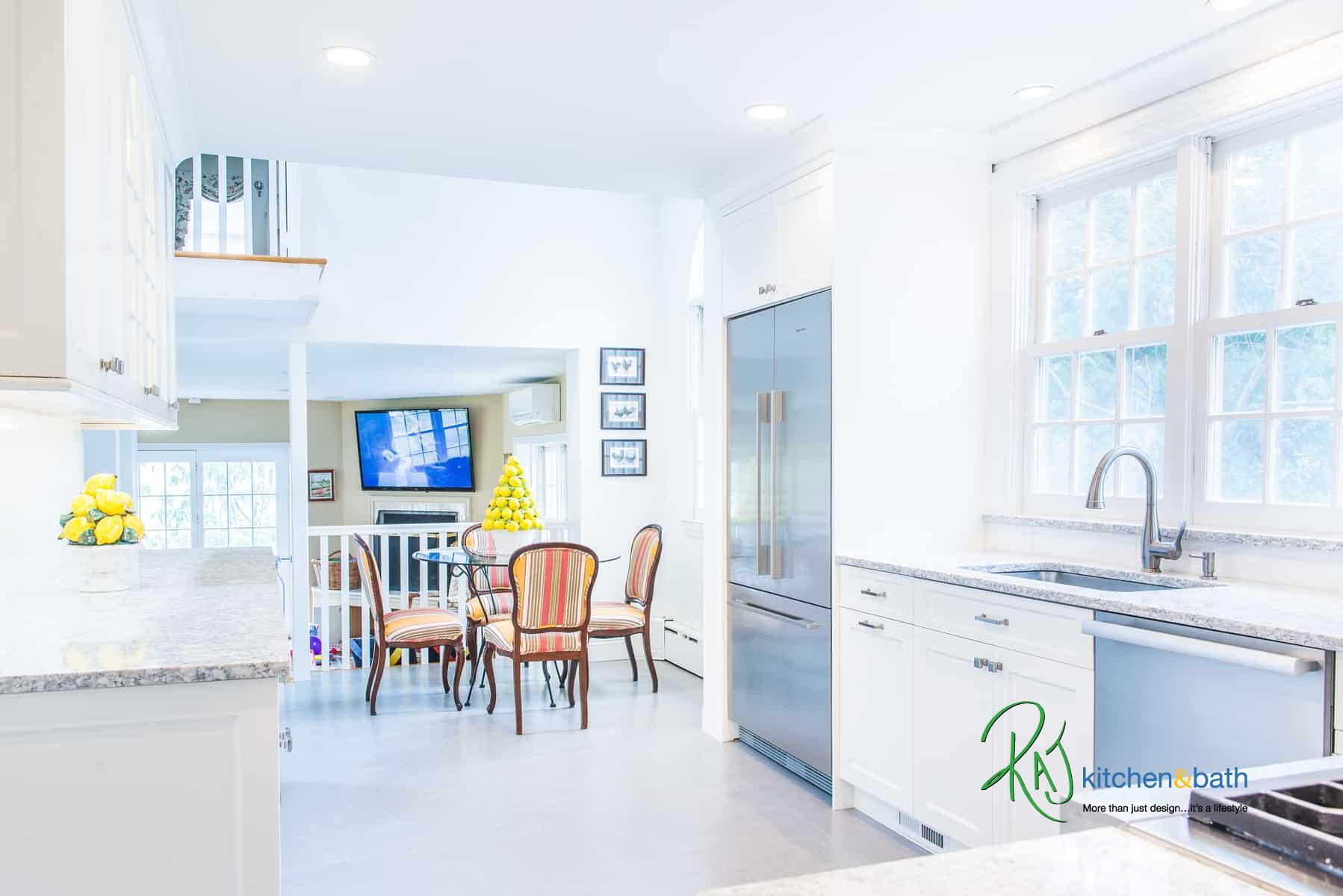 Bright white kitchen remodel in Bronxville NY with stainless steel refrigerator and open dining area